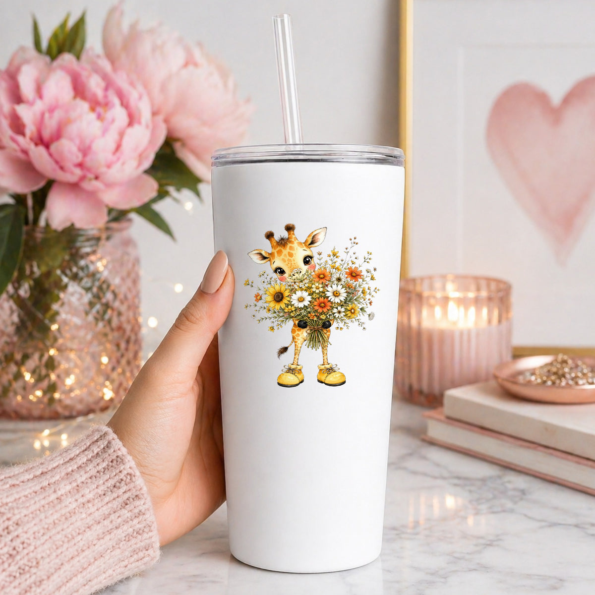 Giraffe Holding Sunflower Bouquet UV DTF sticker applied to a white straw tumbler beside pink peonies