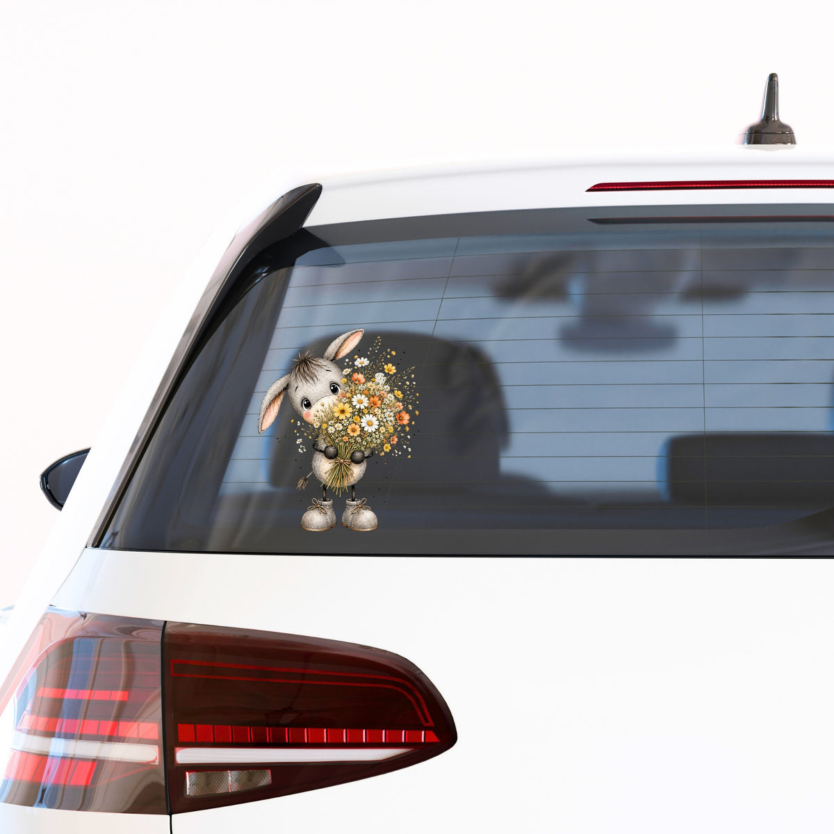 Baby Donkey Holding Wildflower Bouquet UV DTF sticker applied to the rear window of a white car