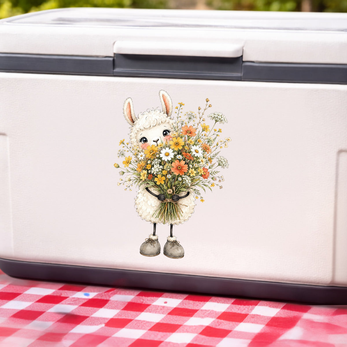 White Llama Holding Daisy Bouquet UV DTF sticker applied to a white cooler on a red gingham cloth