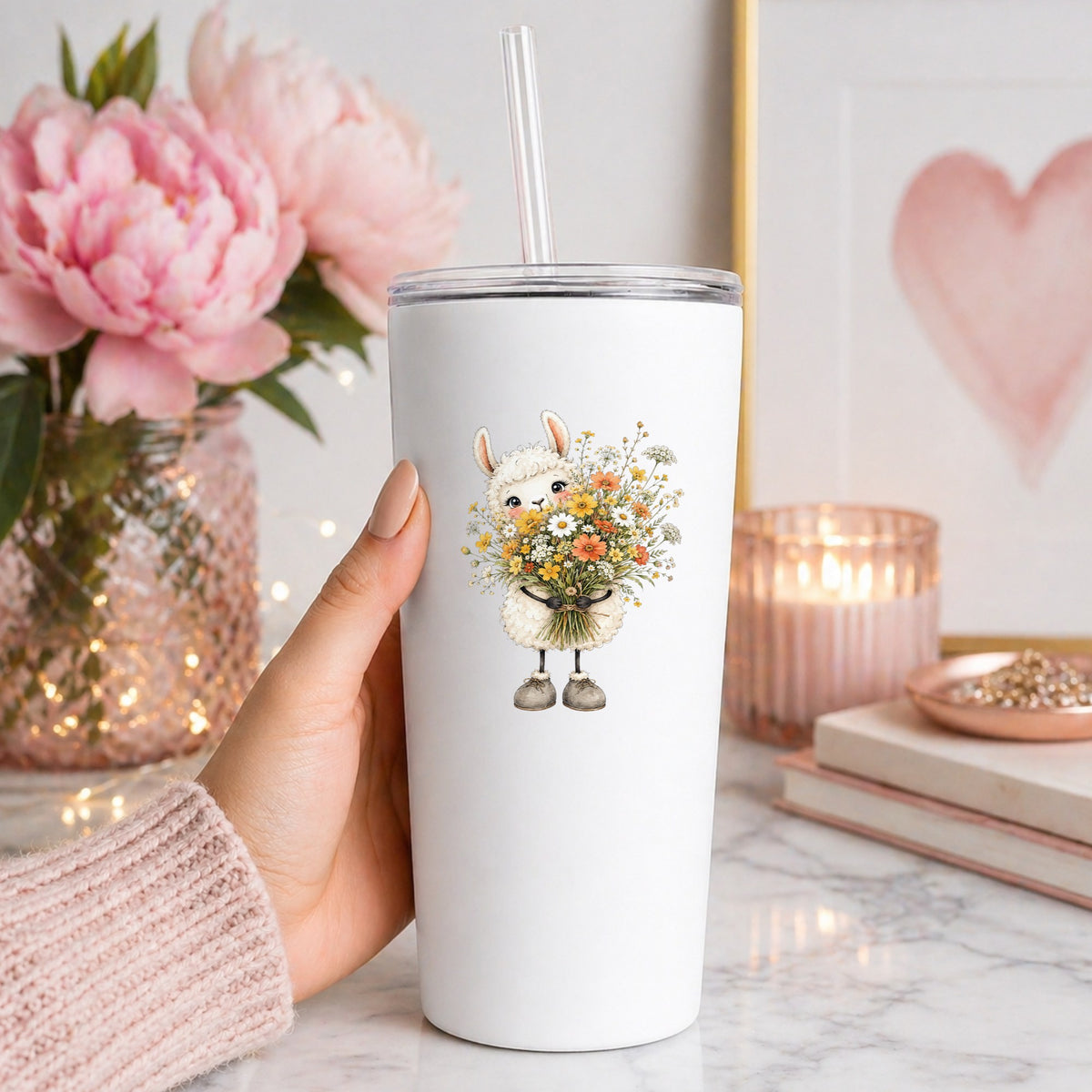White Llama Holding Daisy Bouquet UV DTF sticker applied to a white straw tumbler beside pink peonies