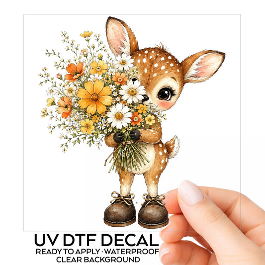 Baby Deer Holding Wildflower Bouquet UV DTF sticker on its backing card, held in hand