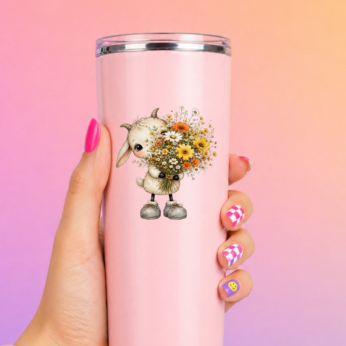 Baby Goat Holding Wildflower Bouquet UV DTF sticker applied to a tall pink tumbler on a pink and orange background