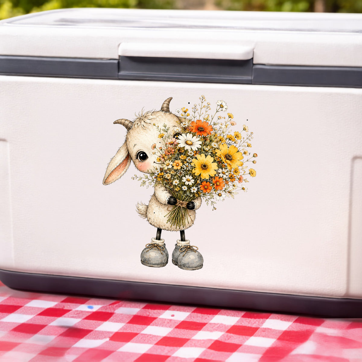 Baby Goat Holding Wildflower Bouquet UV DTF sticker applied to a white cooler on a red gingham cloth