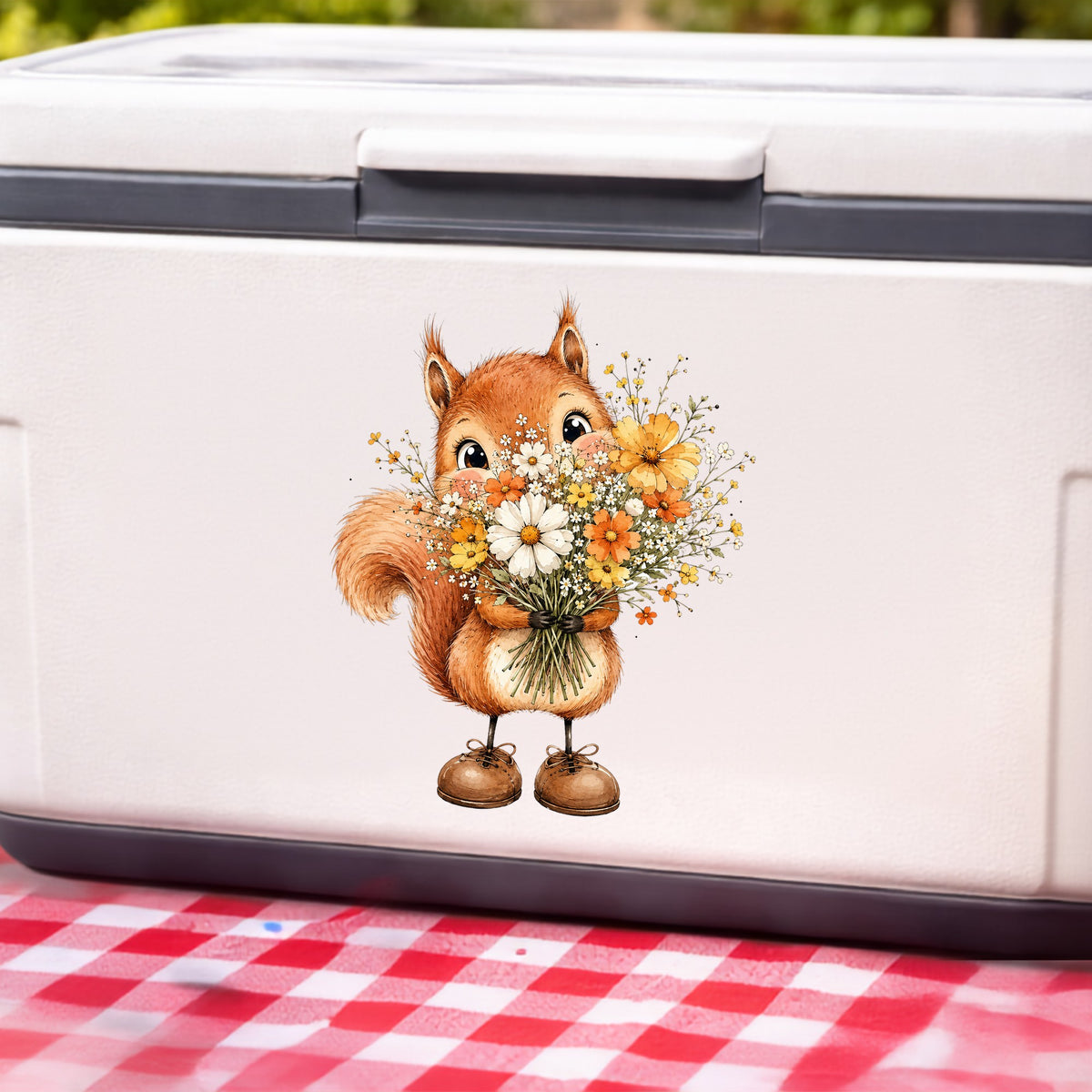 Red Squirrel Holding Daisy Bouquet UV DTF sticker applied to a white cooler on a red gingham cloth