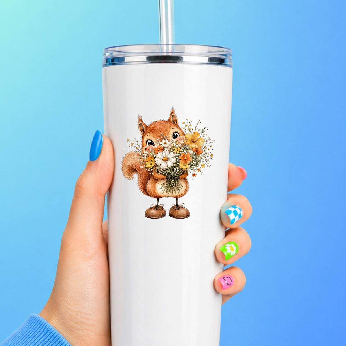 Red Squirrel Holding Daisy Bouquet UV DTF sticker applied to a white straw tumbler on a blue background