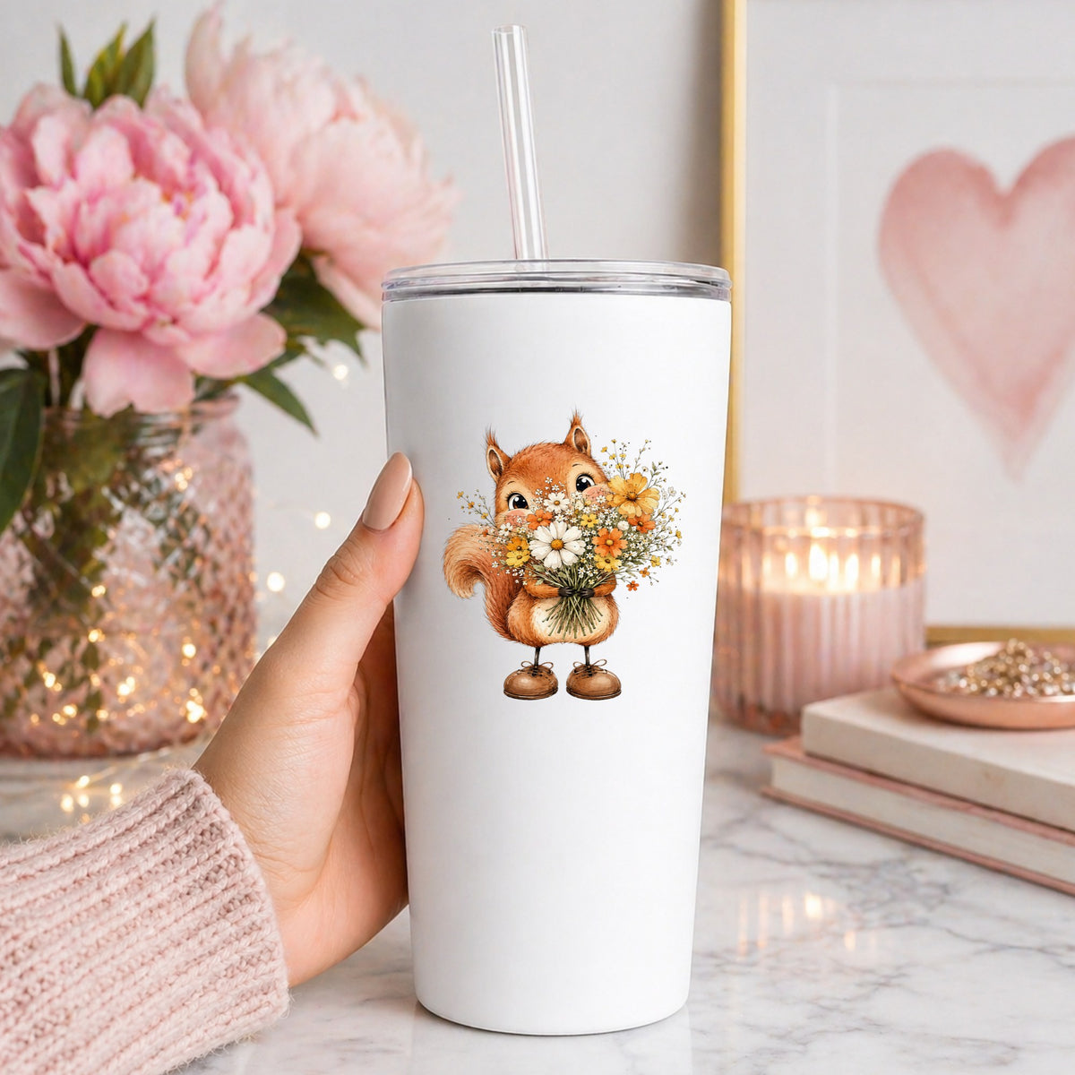 Red Squirrel Holding Daisy Bouquet UV DTF sticker applied to a white straw tumbler beside pink peonies
