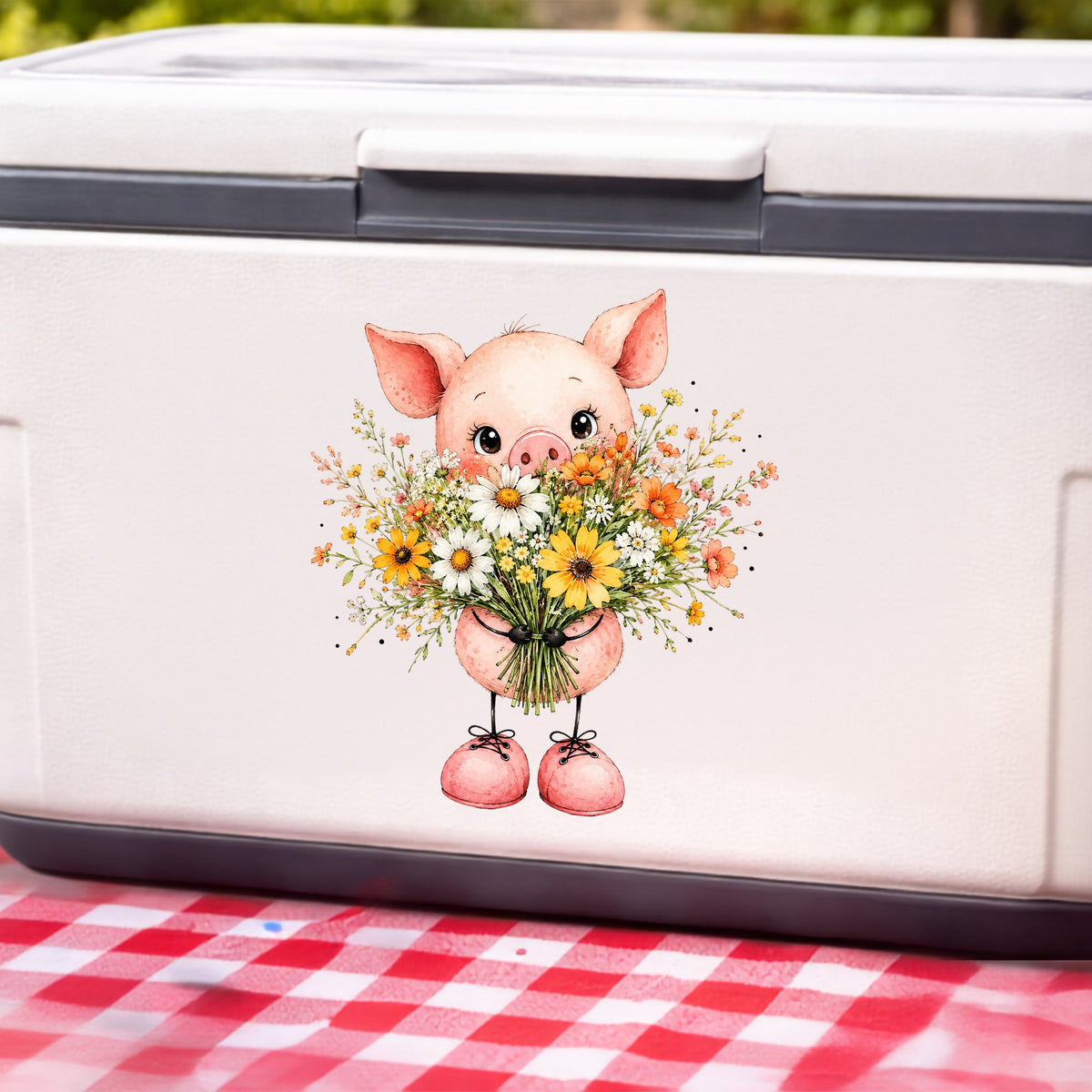 Baby Pig Holding Daisy Bouquet UV DTF sticker applied to a white cooler on a red gingham cloth
