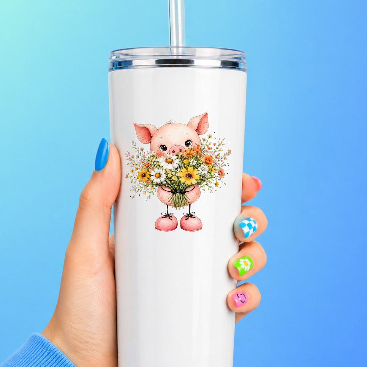 Baby Pig Holding Daisy Bouquet UV DTF sticker applied to a white straw tumbler on a blue background