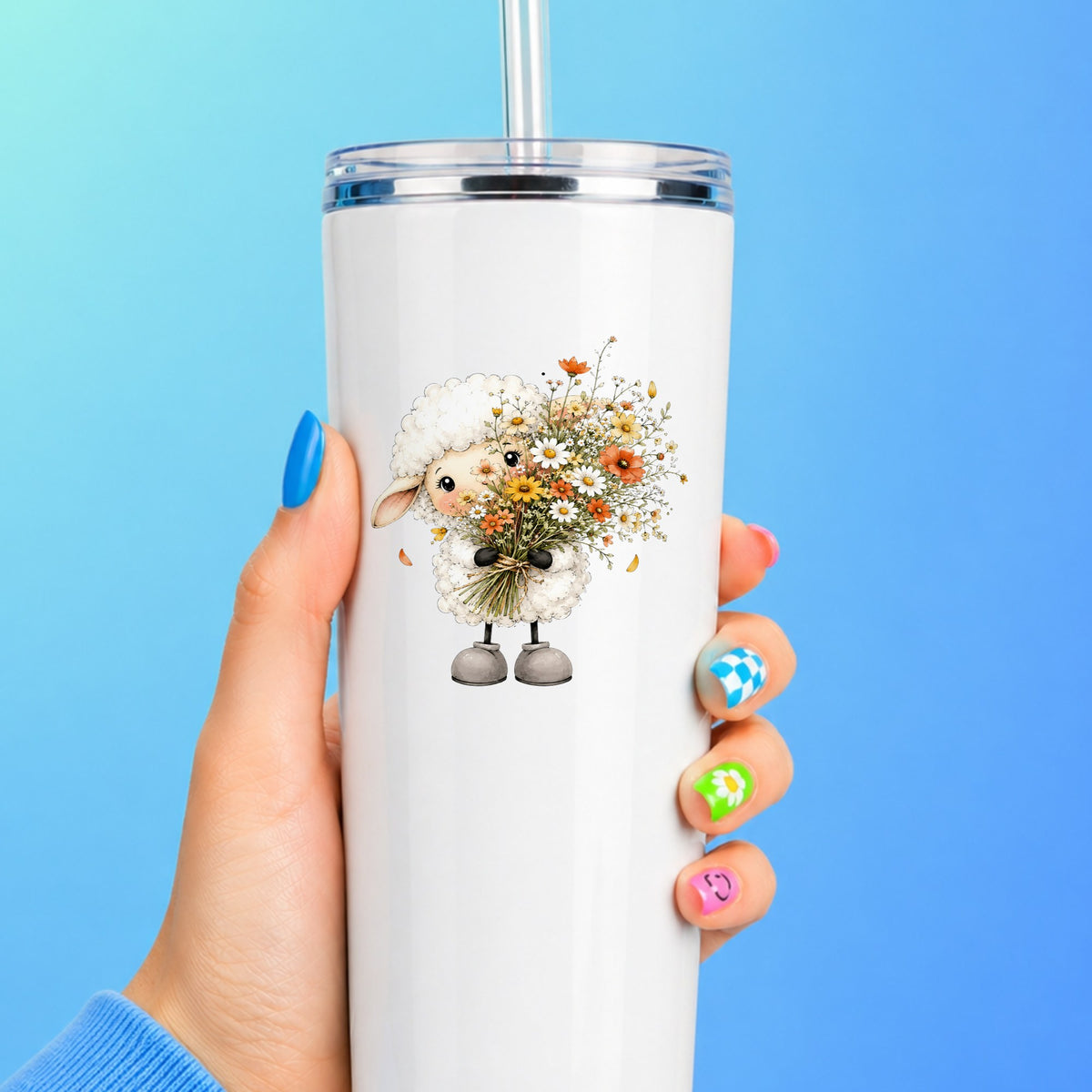 White Lamb Holding Wildflower Bouquet UV DTF sticker applied to a white straw tumbler on a blue background