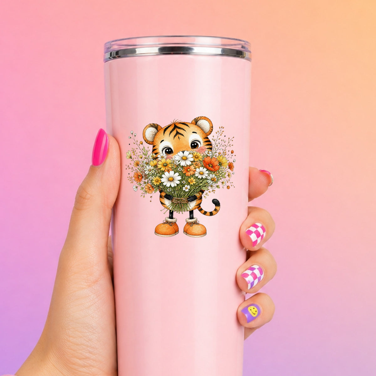 Tiger Cub Holding Wildflower Bouquet UV DTF sticker applied to a tall pink tumbler on a pink and orange background