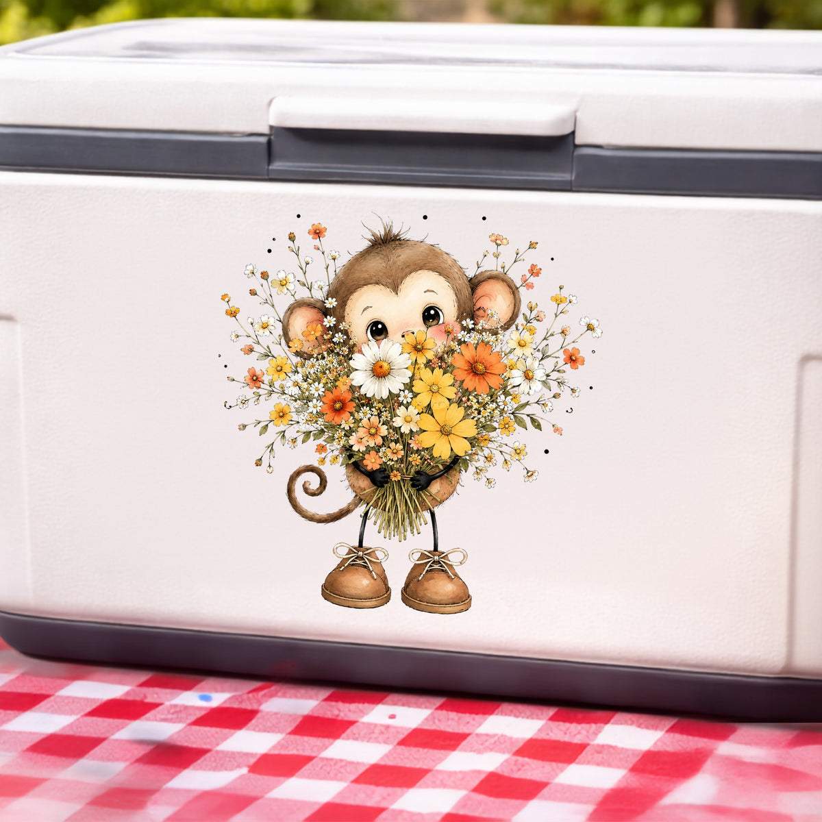 Baby Monkey Holding Daisy Bouquet UV DTF sticker applied to a white cooler on a red gingham cloth