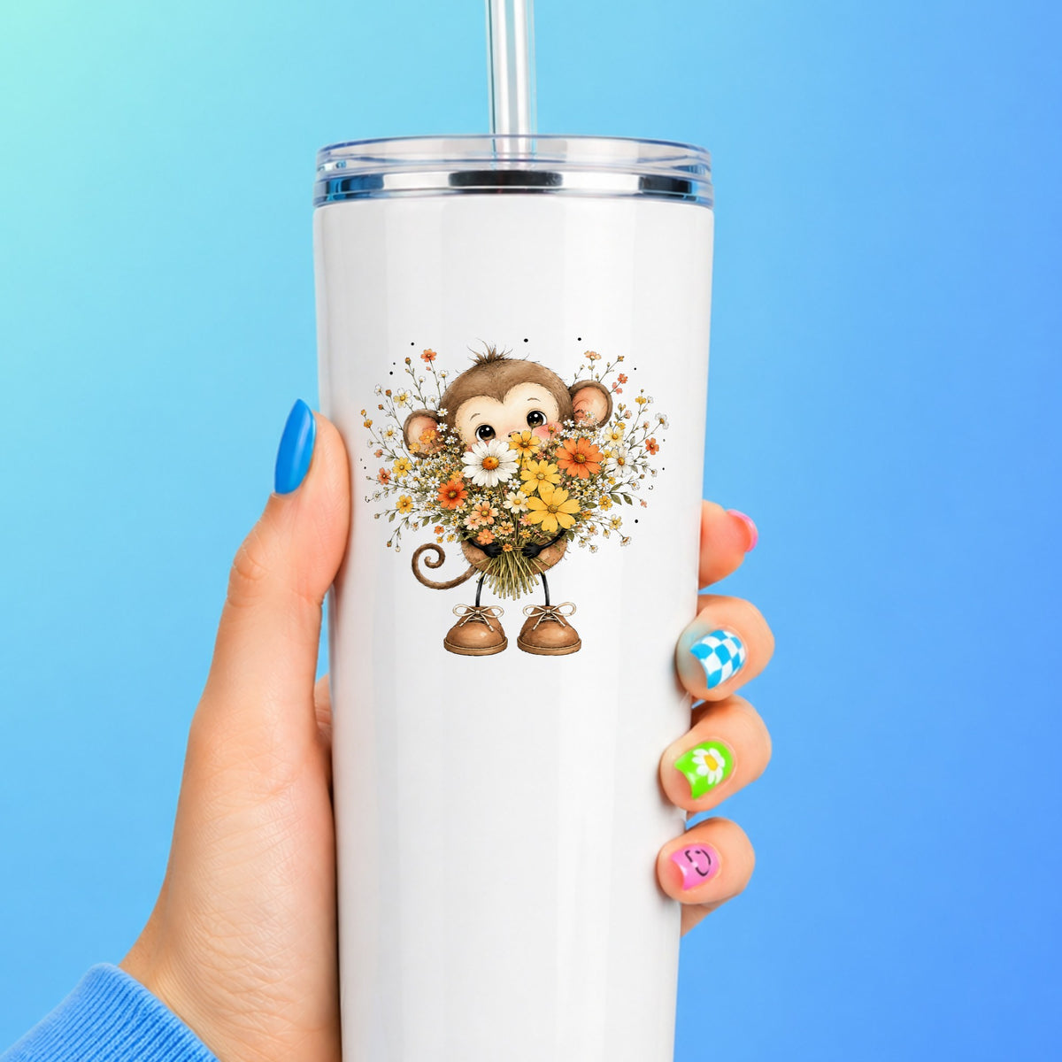 Baby Monkey Holding Daisy Bouquet UV DTF sticker applied to a white straw tumbler on a blue background