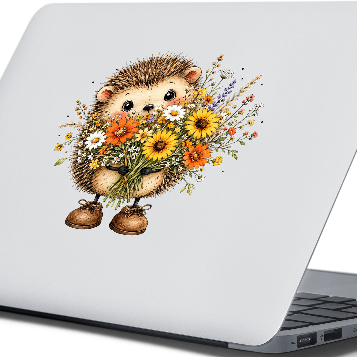 Hedgehog Holding Wildflower Bouquet UV DTF sticker applied to the lid of a silver laptop