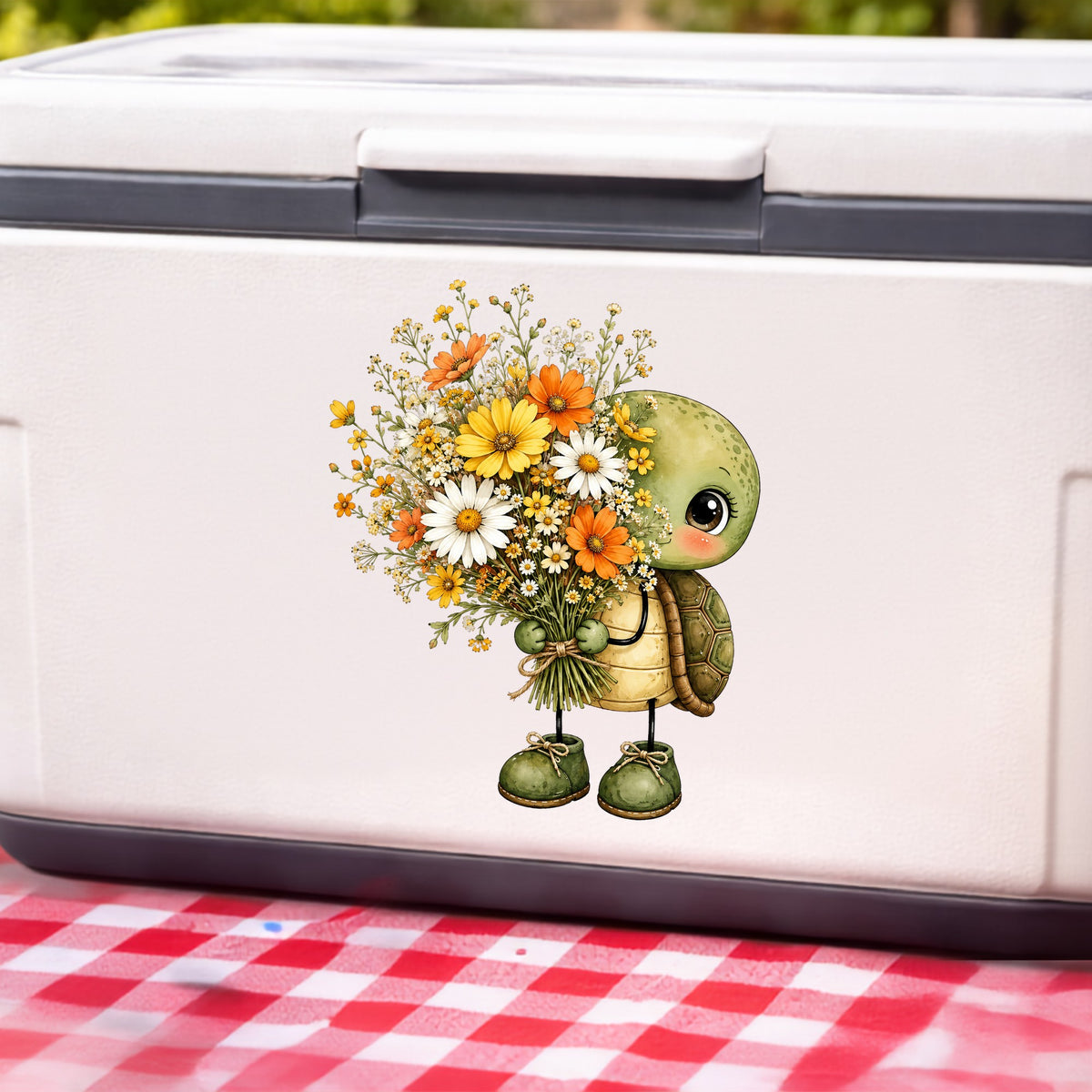 Baby Turtle Holding Wildflower Bouquet UV DTF sticker applied to a white cooler on a red gingham cloth