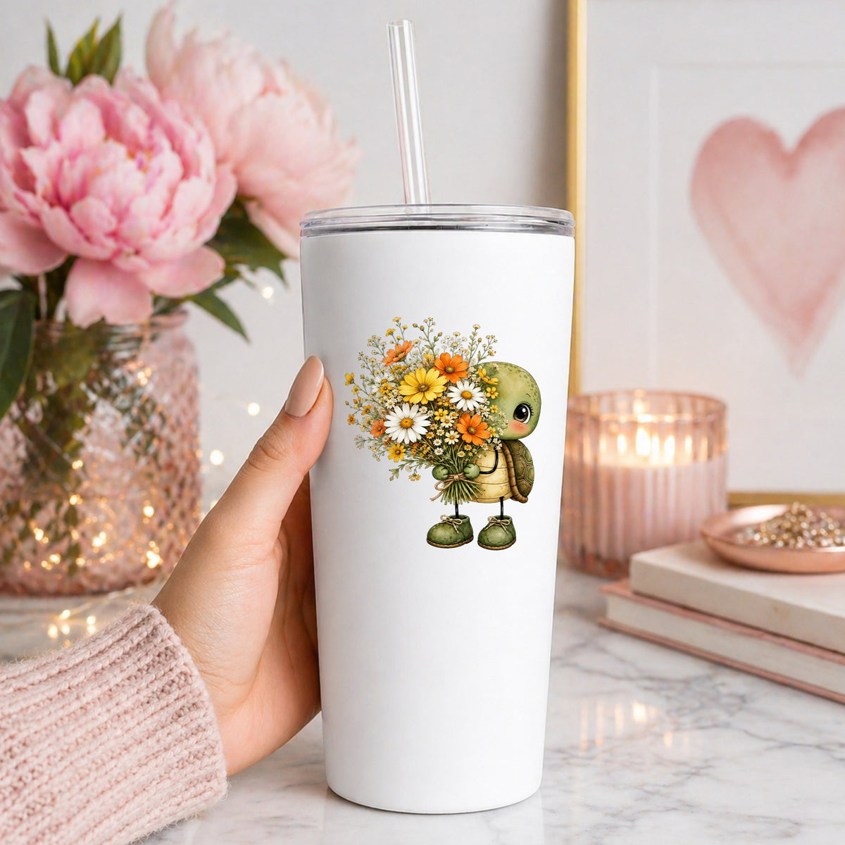 Baby Turtle Holding Wildflower Bouquet UV DTF sticker applied to a white straw tumbler beside pink peonies