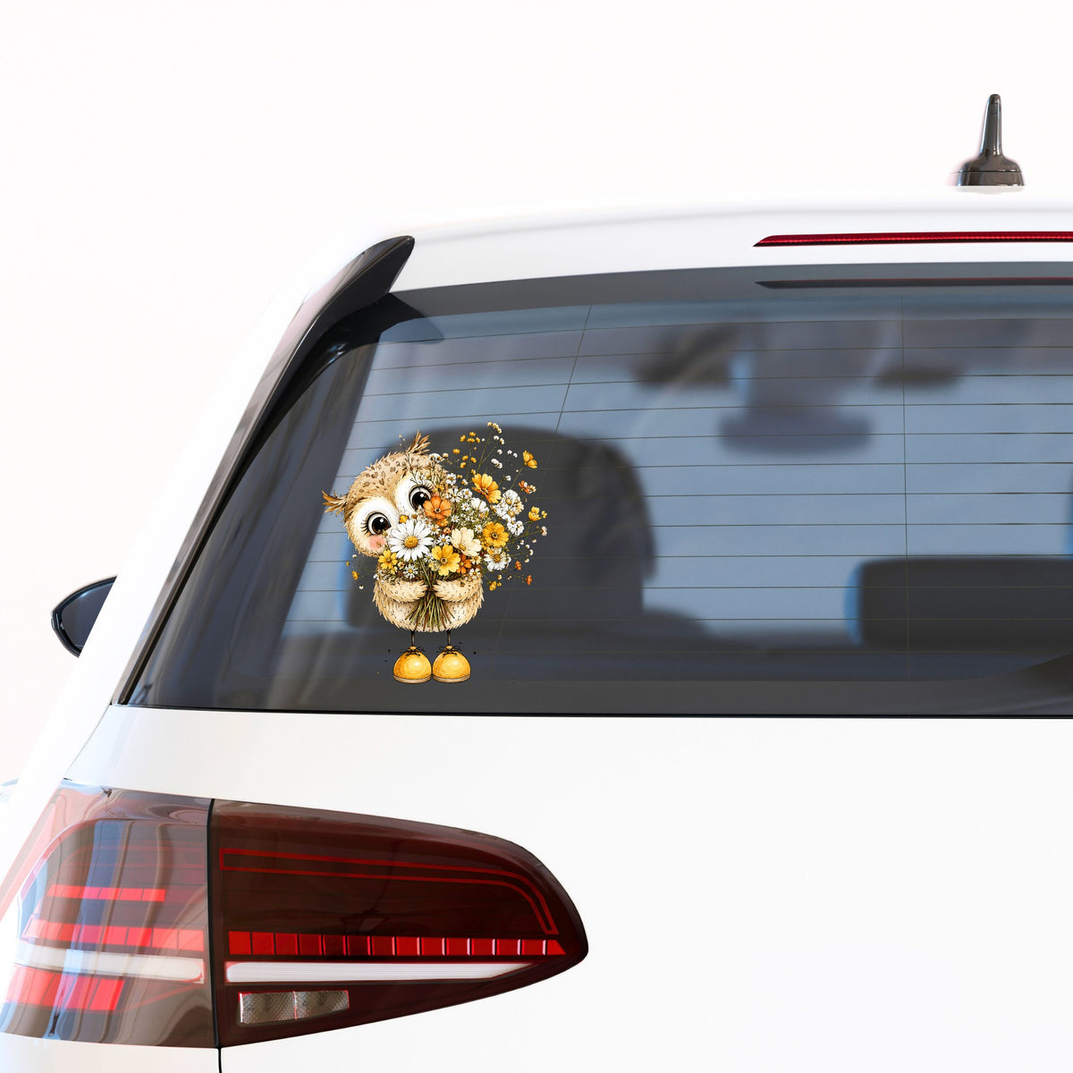 Baby Owl Holding Wildflower Bouquet UV DTF sticker applied to the rear window of a white car