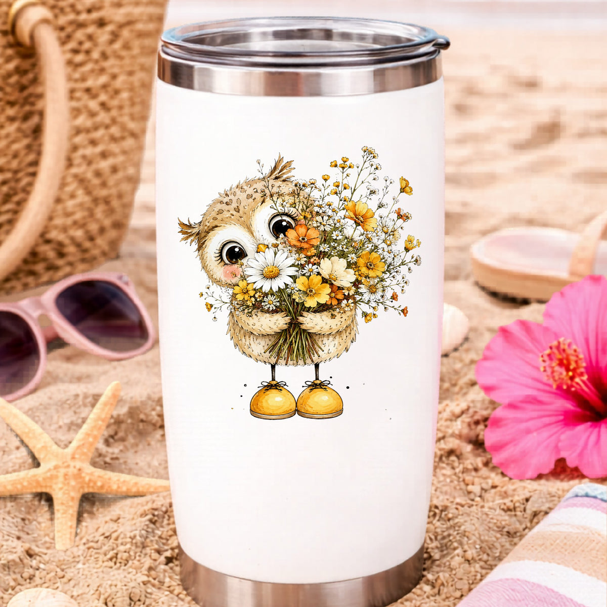 Baby Owl Holding Wildflower Bouquet UV DTF sticker applied to a white travel tumbler on beach sand