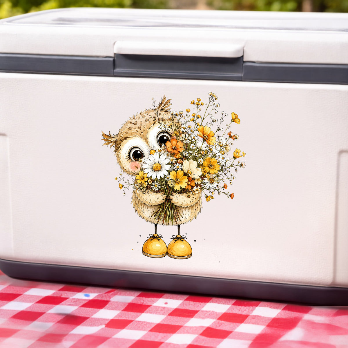 Baby Owl Holding Wildflower Bouquet UV DTF sticker applied to a white cooler on a red gingham cloth