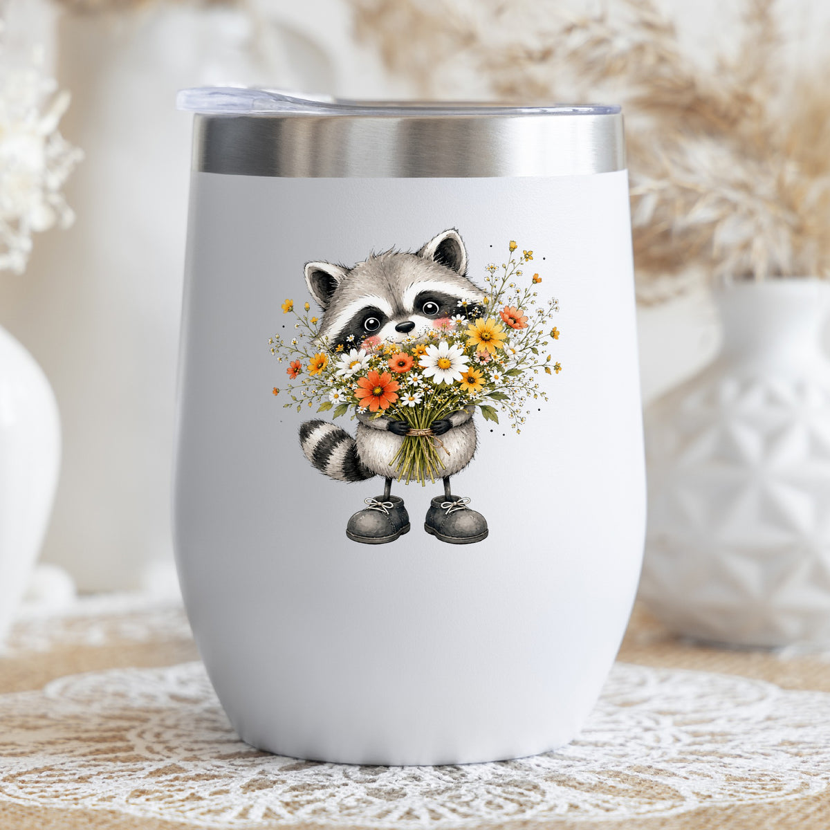 Raccoon Holding Wildflower Bouquet UV DTF sticker applied to a white stemless tumbler with a lid