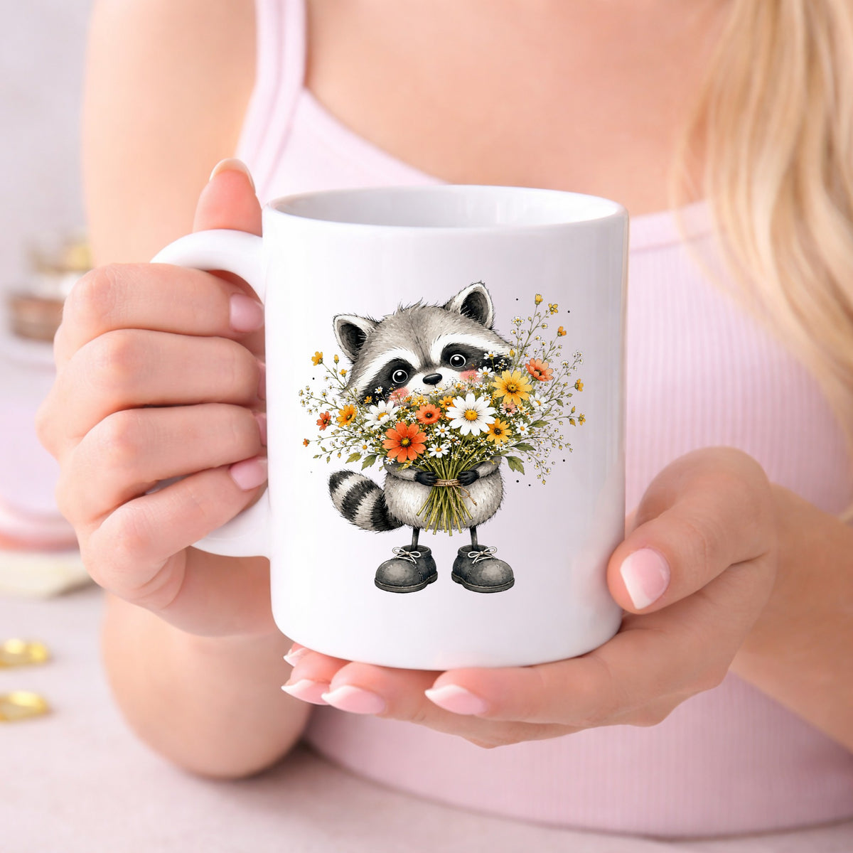 Raccoon Holding Wildflower Bouquet UV DTF sticker applied to a white coffee mug held in both hands