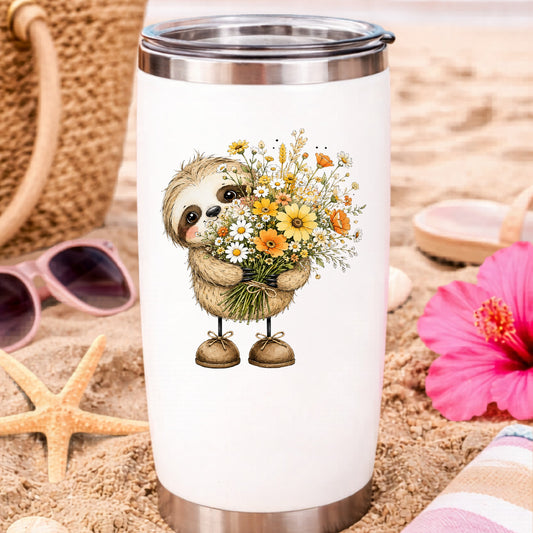 Baby Sloth Holding Wildflower Bouquet UV DTF sticker applied to a white travel tumbler on beach sand
