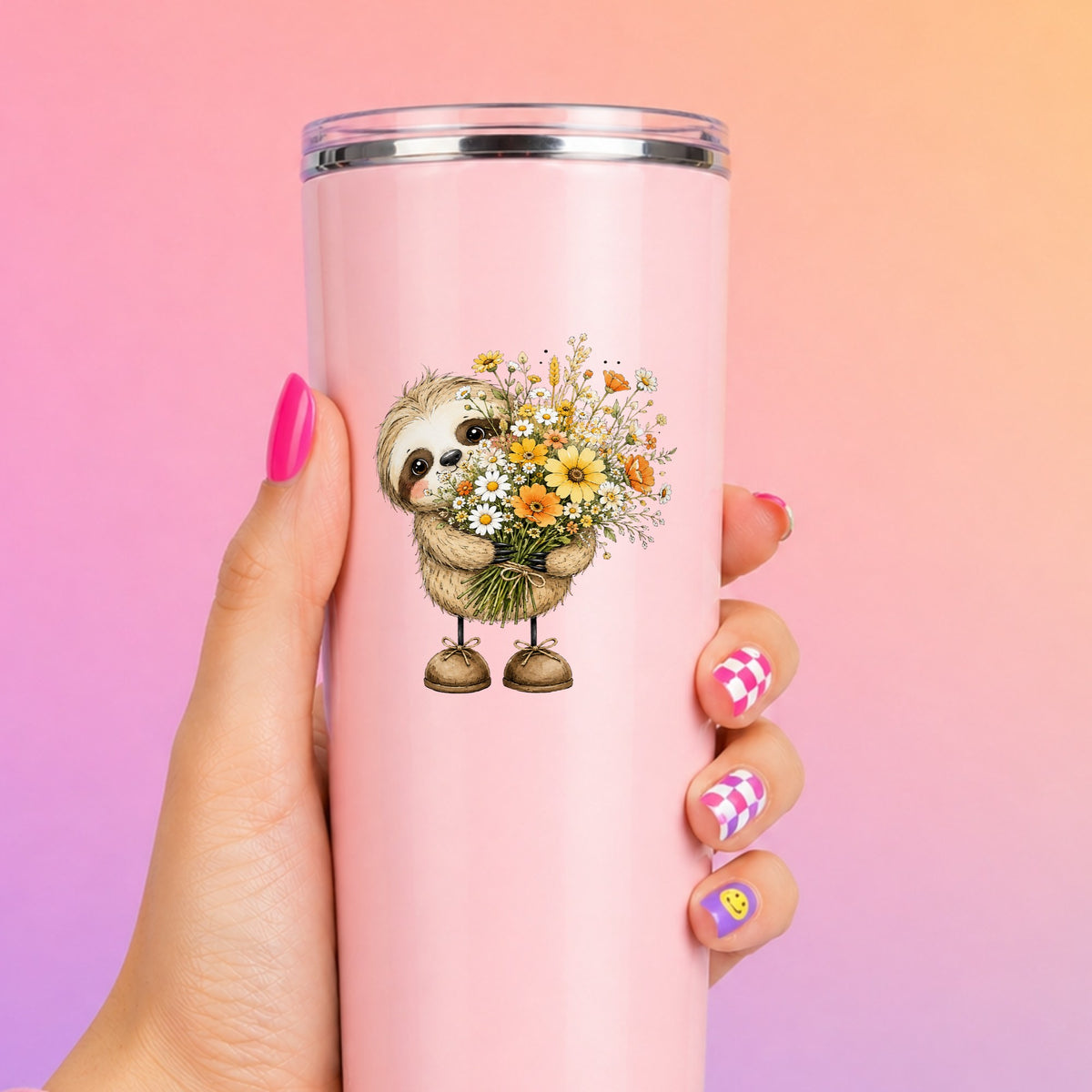 Baby Sloth Holding Wildflower Bouquet UV DTF sticker applied to a tall pink tumbler on a pink and orange background