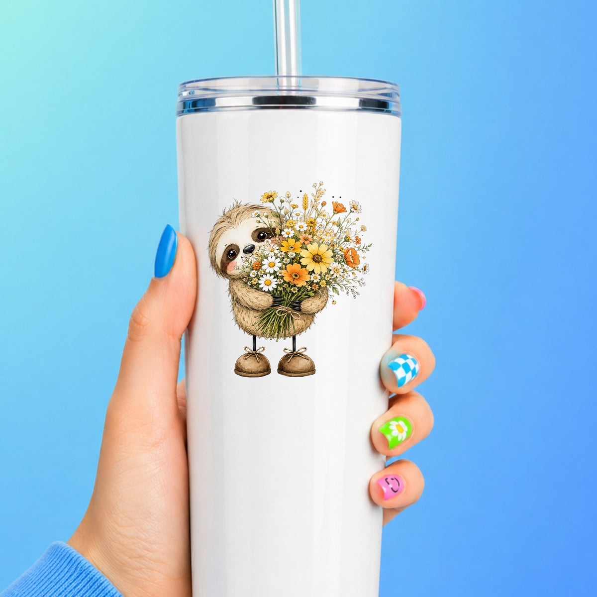 Baby Sloth Holding Wildflower Bouquet UV DTF sticker applied to a white straw tumbler on a blue background
