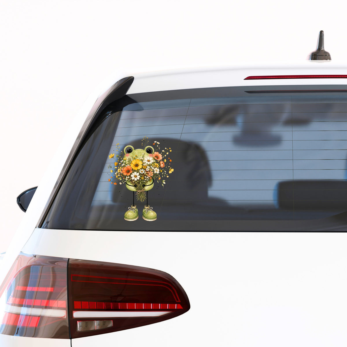 Green Frog Holding Wildflower Bouquet UV DTF sticker applied to the rear window of a white car