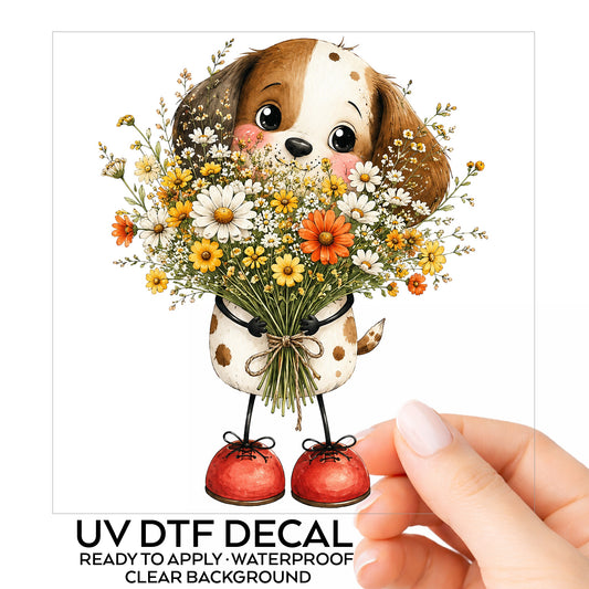 Brown Puppy Holding Daisy Bouquet UV DTF sticker on its backing card, held in hand
