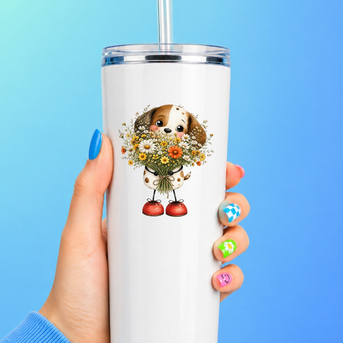 Brown Puppy Holding Daisy Bouquet UV DTF sticker applied to a white straw tumbler on a blue background