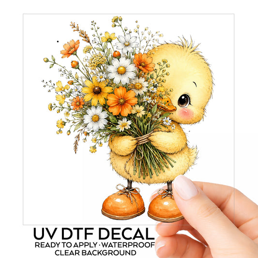 Yellow Duckling Holding Daisy Bouquet UV DTF sticker on its backing card, held in hand