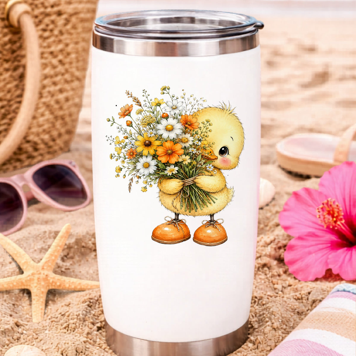 Yellow Duckling Holding Daisy Bouquet UV DTF sticker applied to a white travel tumbler on beach sand