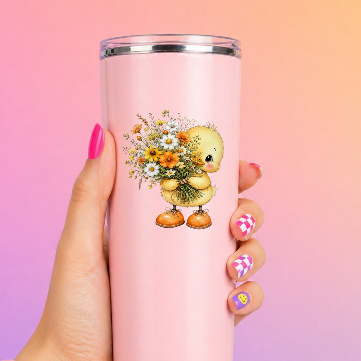 Yellow Duckling Holding Daisy Bouquet UV DTF sticker applied to a tall pink tumbler on a pink and orange background