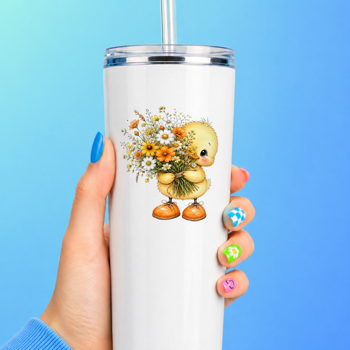 Yellow Duckling Holding Daisy Bouquet UV DTF sticker applied to a white straw tumbler on a blue background