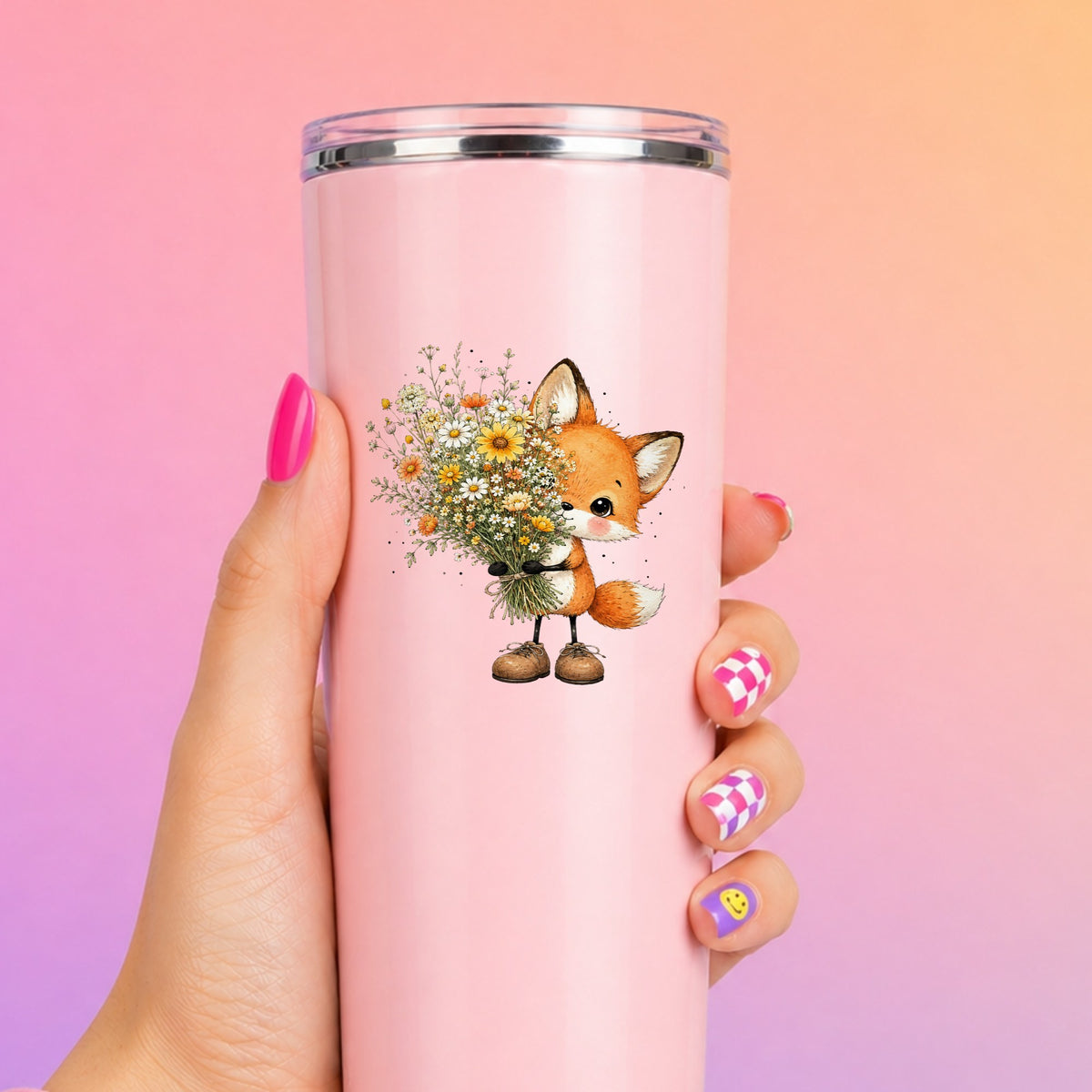 Baby Fox Holding Wildflower Bouquet UV DTF sticker applied to a tall pink tumbler on a pink and orange background