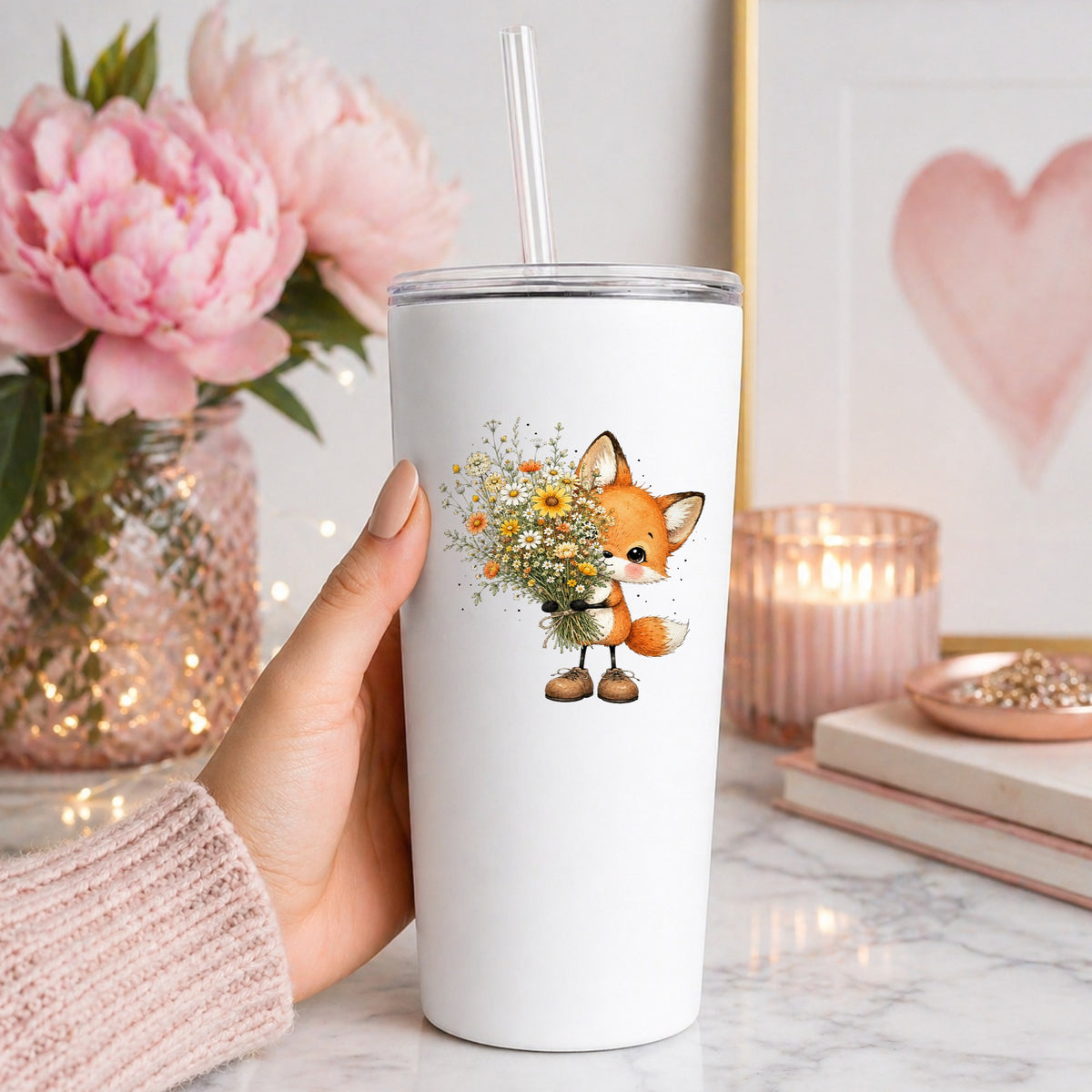 Baby Fox Holding Wildflower Bouquet UV DTF sticker applied to a white straw tumbler beside pink peonies