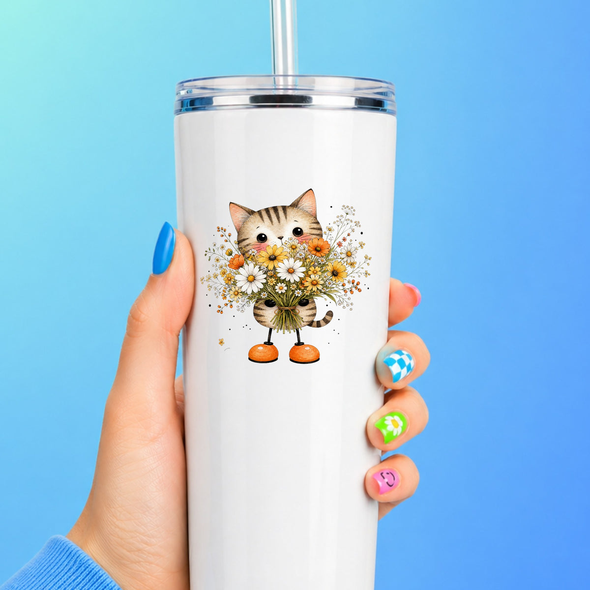 Tabby Cat Holding Daisy Bouquet UV DTF sticker applied to a white straw tumbler on a blue background