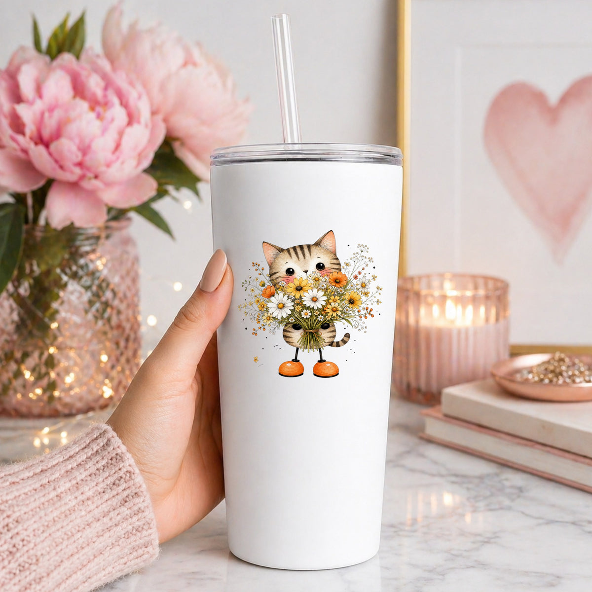 Tabby Cat Holding Daisy Bouquet UV DTF sticker applied to a white straw tumbler beside pink peonies