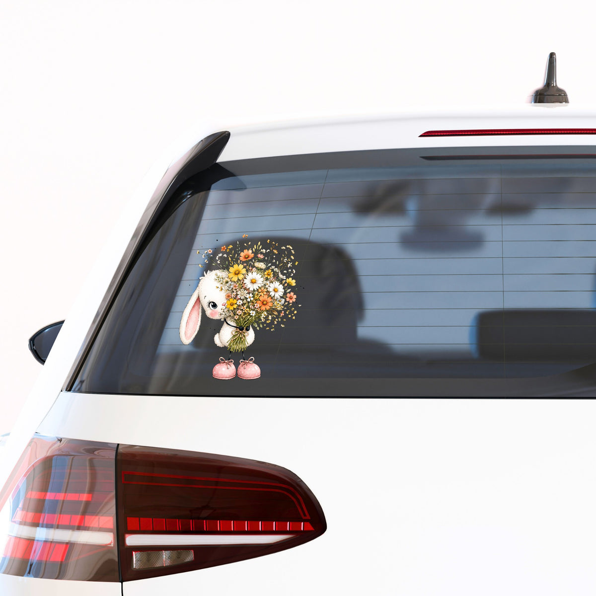 White Bunny Holding Wildflower Bouquet UV DTF sticker applied to the rear window of a white car