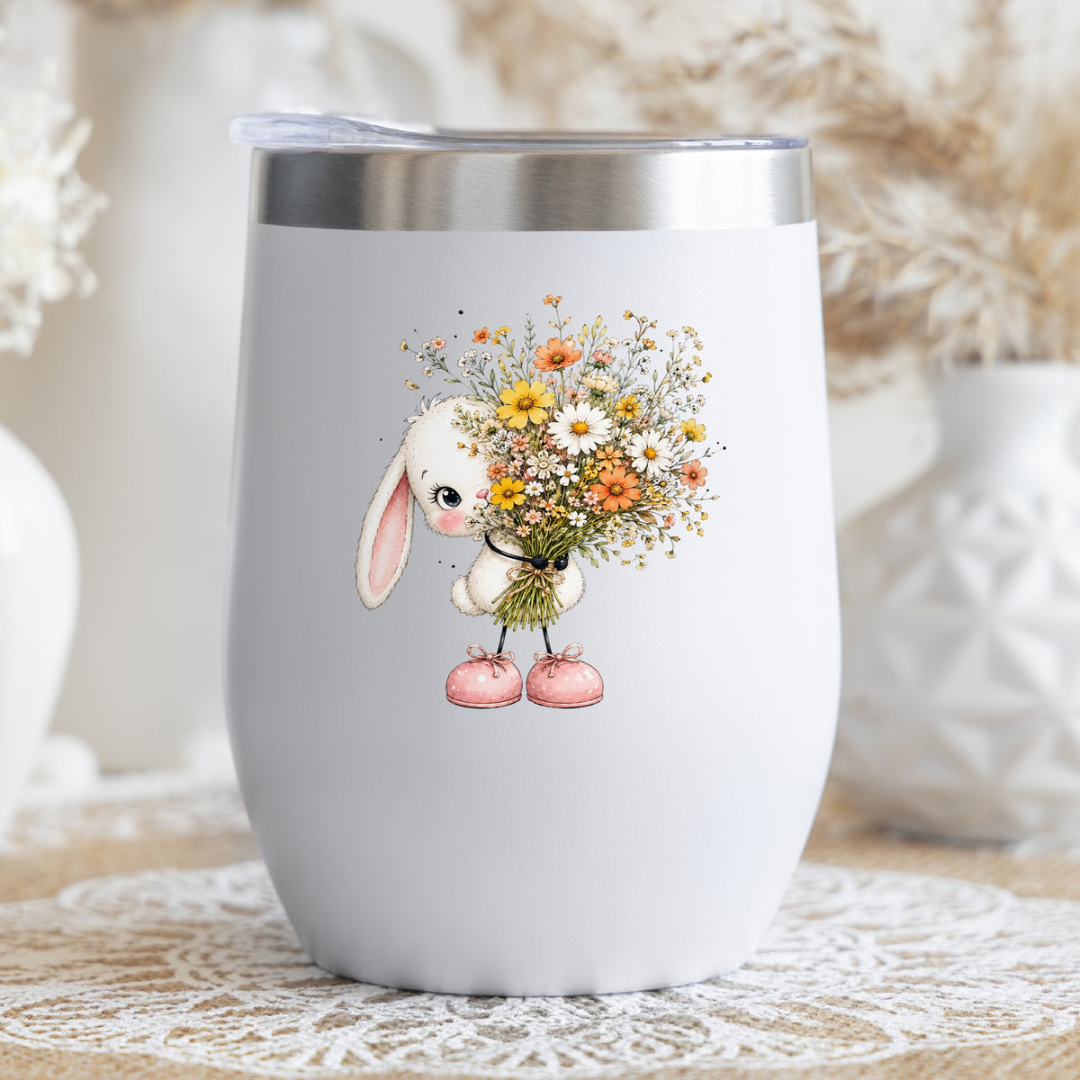 White Bunny Holding Wildflower Bouquet UV DTF sticker applied to a white stemless tumbler with a lid