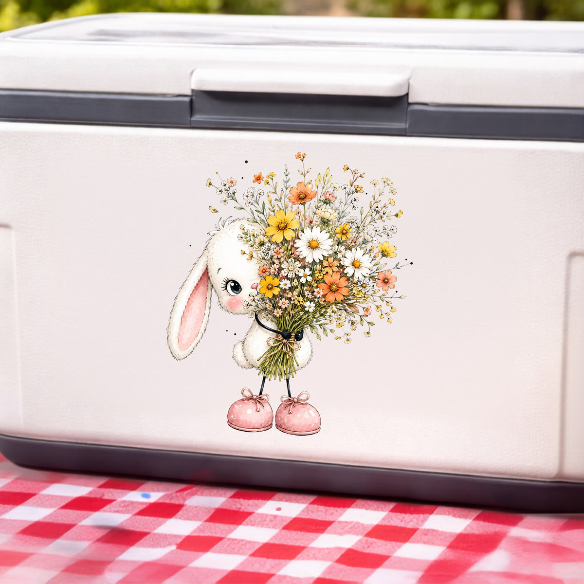 White Bunny Holding Wildflower Bouquet UV DTF sticker applied to a white cooler on a red gingham cloth