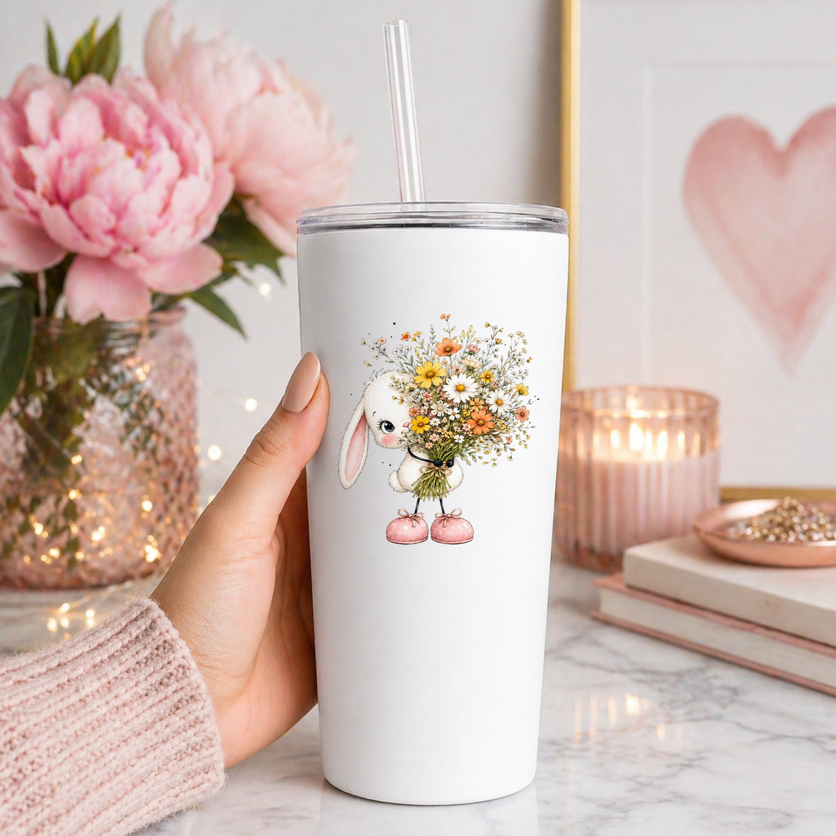 White Bunny Holding Wildflower Bouquet UV DTF sticker applied to a white straw tumbler beside pink peonies