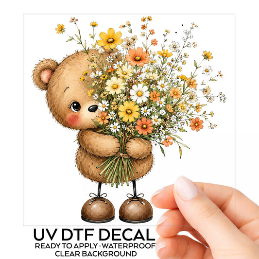 Teddy Bear Holding Wildflower Bouquet UV DTF sticker on its backing card, held in hand