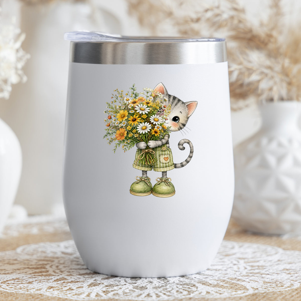 Grey Kitten In Overalls Holding Flowers UV DTF sticker applied to a white stemless tumbler with a lid