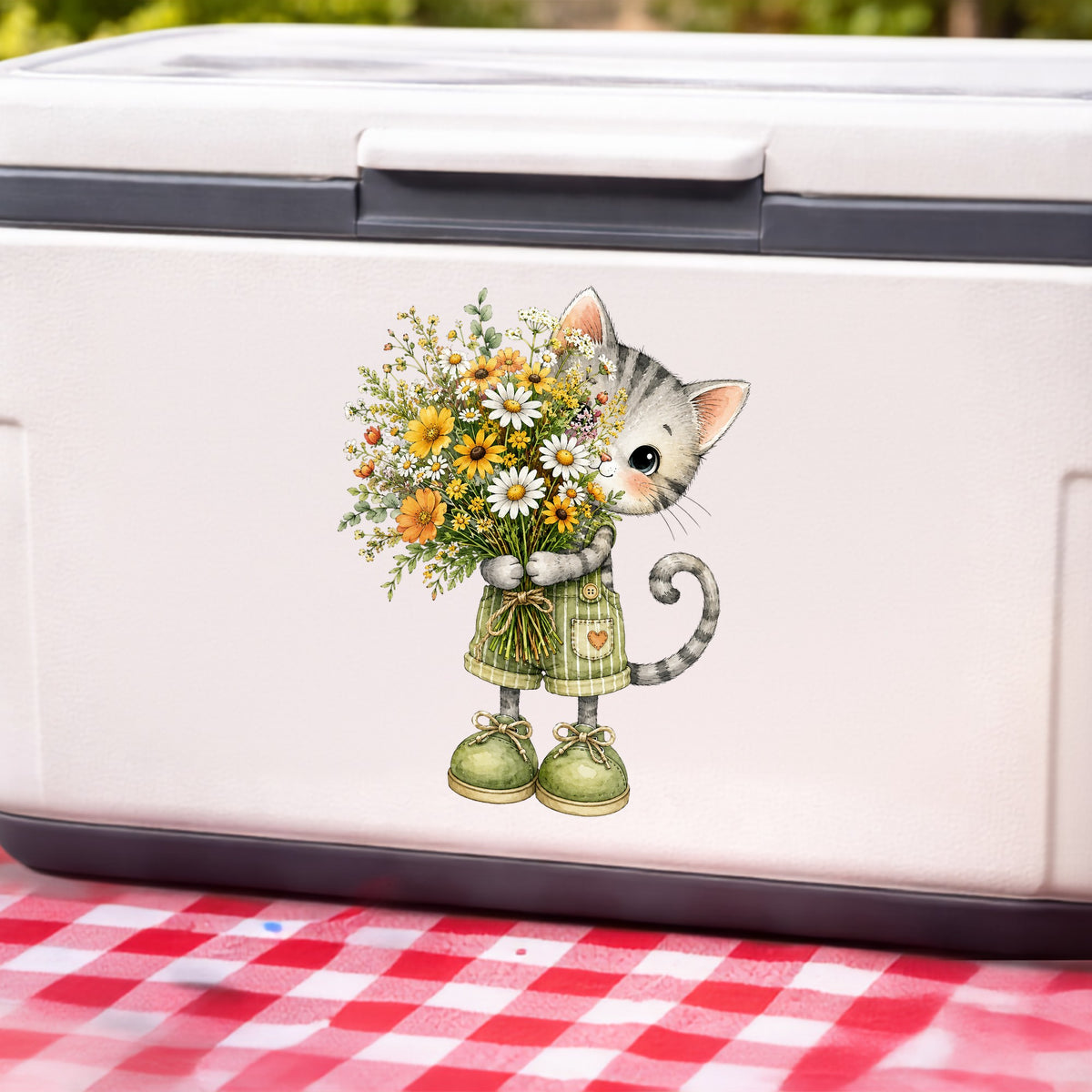 Grey Kitten In Overalls Holding Flowers UV DTF sticker applied to a white cooler on a red gingham cloth