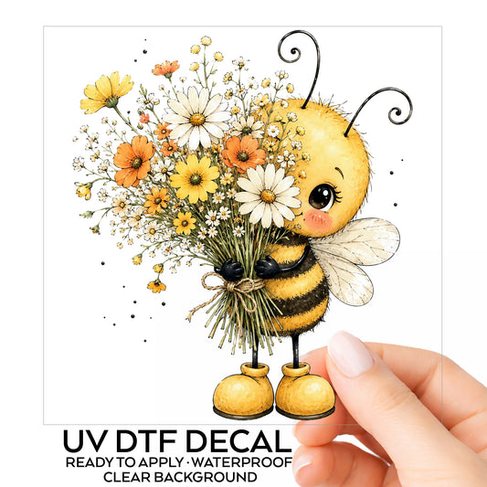 Honey Bee Holding Wildflower Bouquet UV DTF sticker on its backing card, held in hand