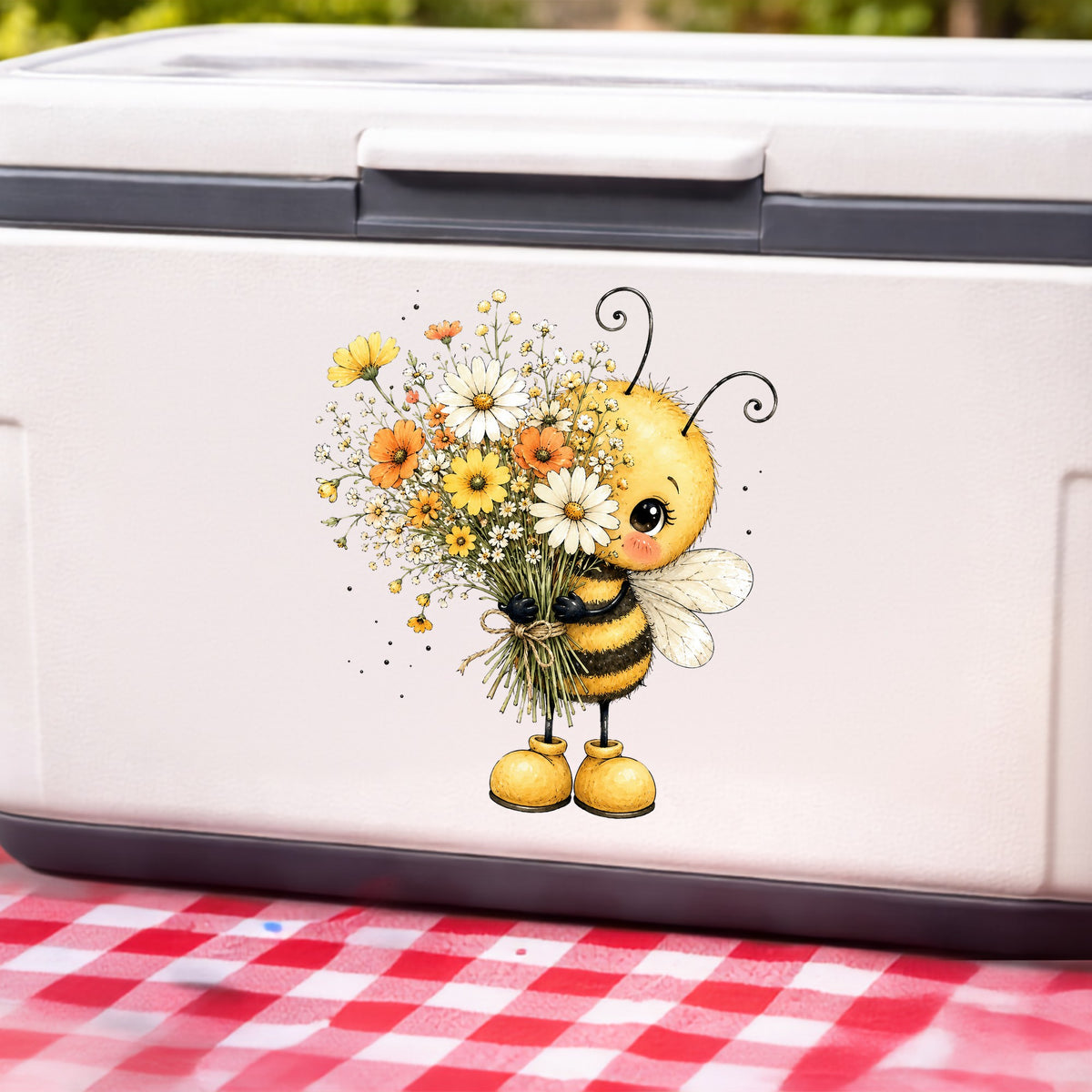 Honey Bee Holding Wildflower Bouquet UV DTF sticker applied to a white cooler on a red gingham cloth