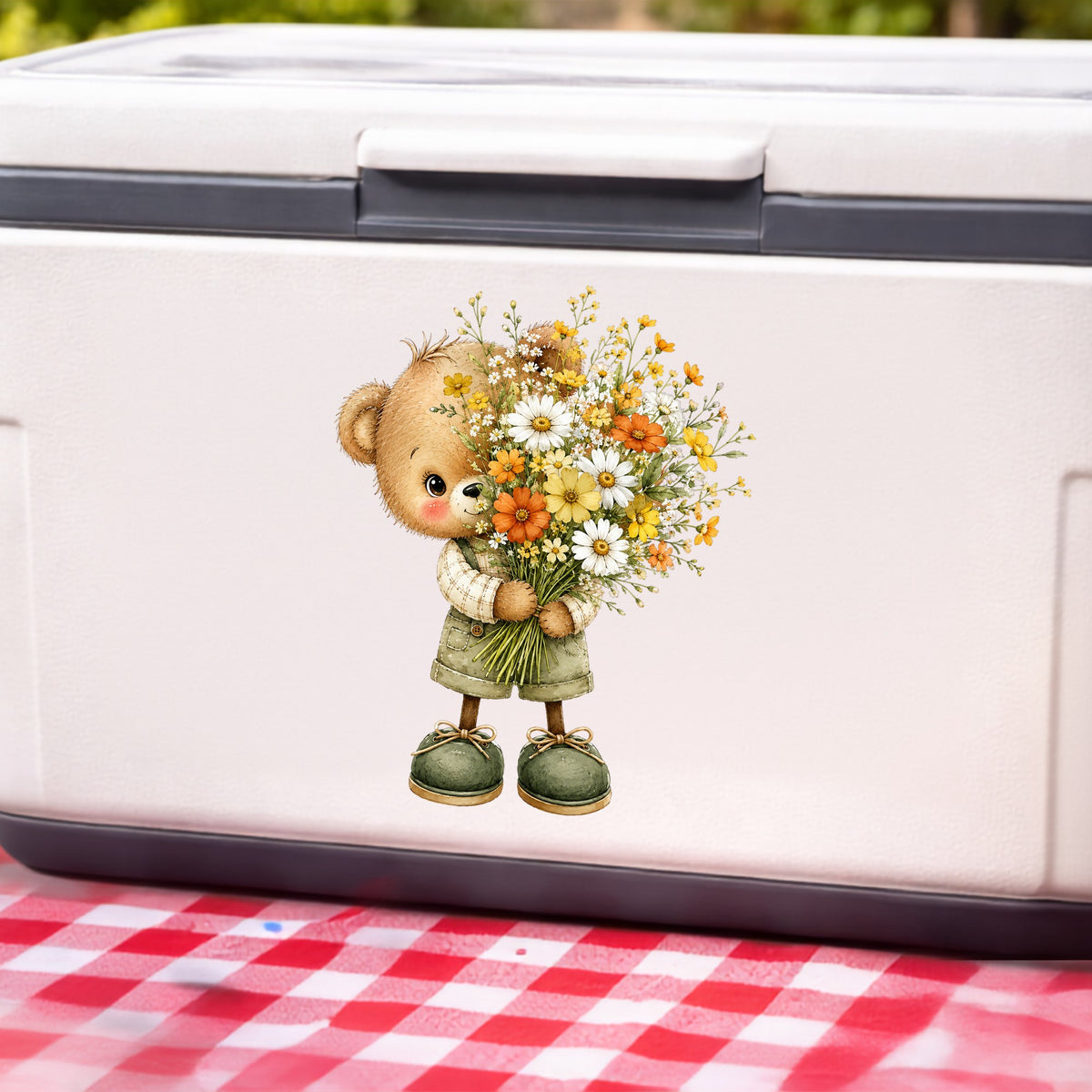 Brown Bear In Overalls Holding Daisy Bouquet UV DTF sticker applied to a white cooler on a red gingham cloth