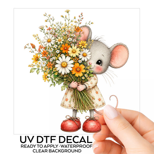 Mouse In Floral Dress Holding Flowers UV DTF sticker on its backing card, held in hand