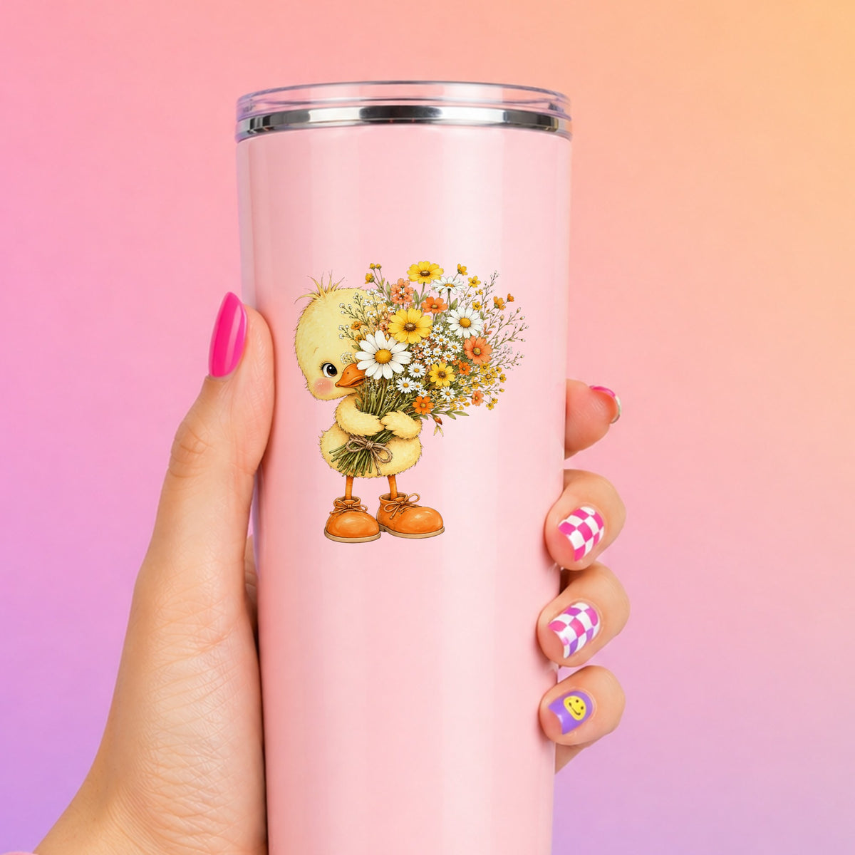 Baby Duck Holding Wildflower Bouquet UV DTF sticker applied to a tall pink tumbler on a pink and orange background